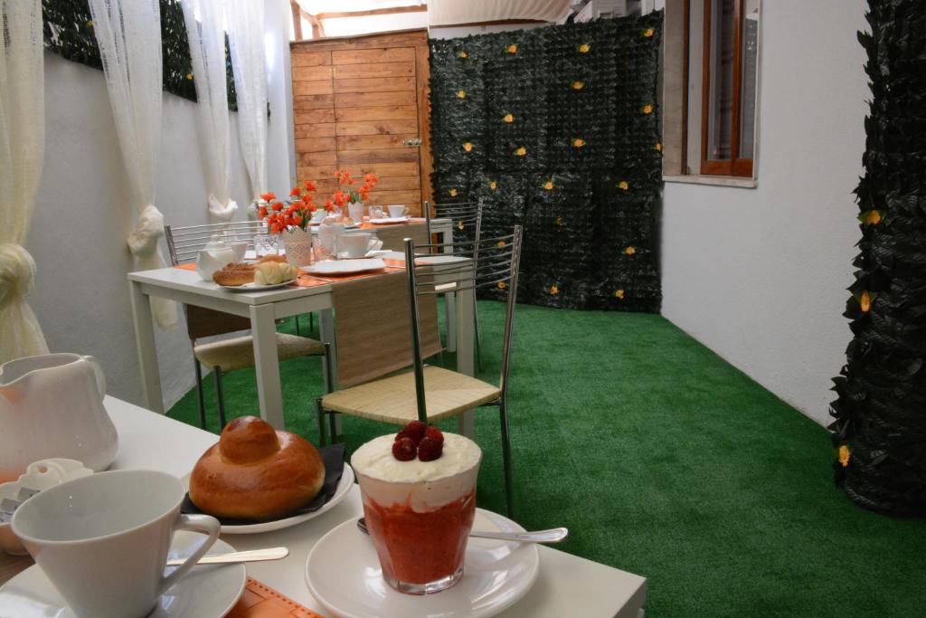 un comedor con alfombra verde y una mesa con una bebida en B&B Crystal, en Messina