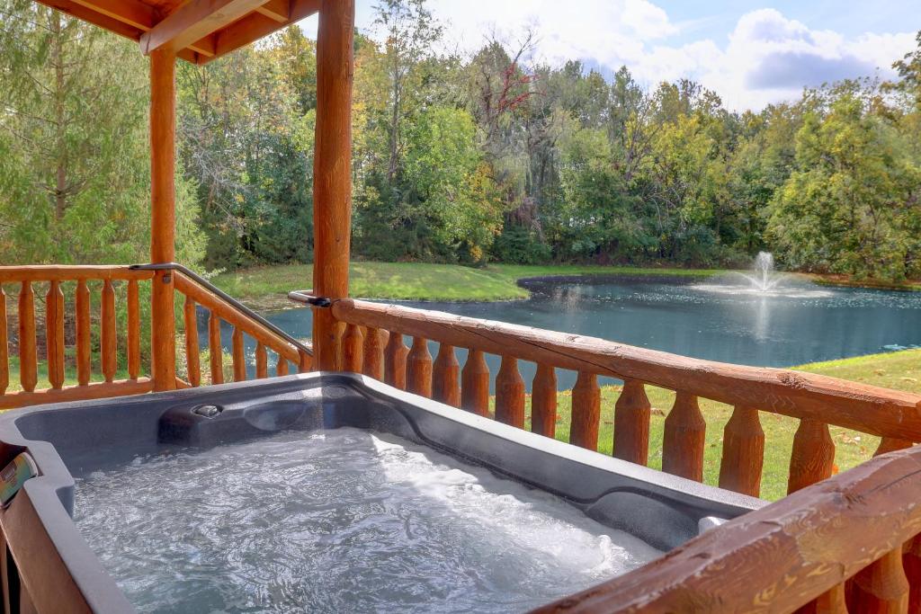 bañera de hidromasaje en una terraza con estanque en Waterview Lodge by Amish Country Lodging en Millersburg