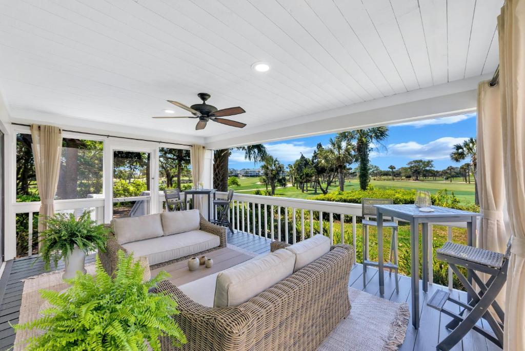 a porch with a couch and a ceiling fan at 461 Golf Shore Villa in Seabrook Island
