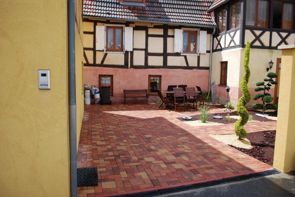 an outside view of a house with a brick patio at la grange in Wintzenheim