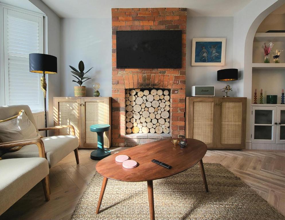 a living room with a brick fireplace with a table at The Neptune in Henley on Thames