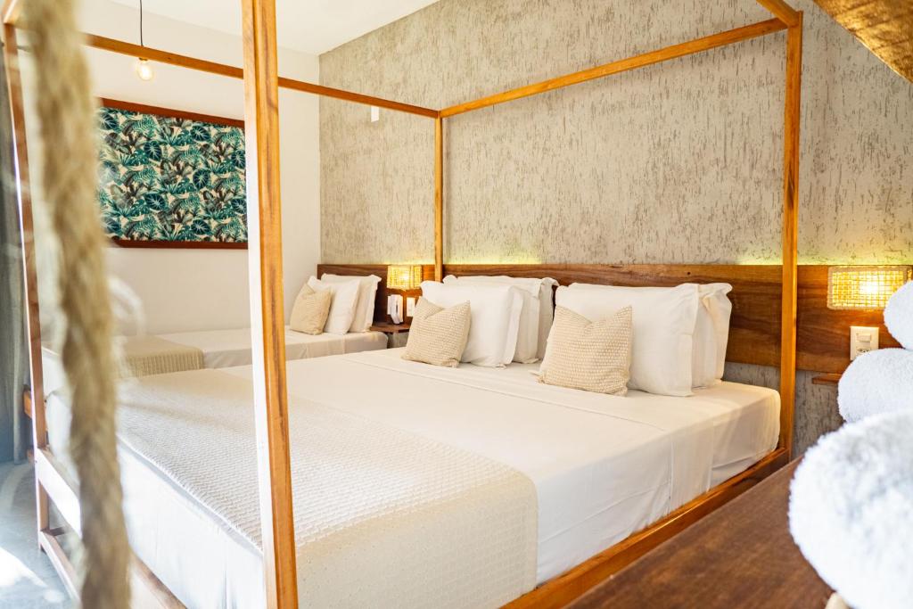 two beds in a room with a mirror at Casa Valentini Pousada in Jericoacoara