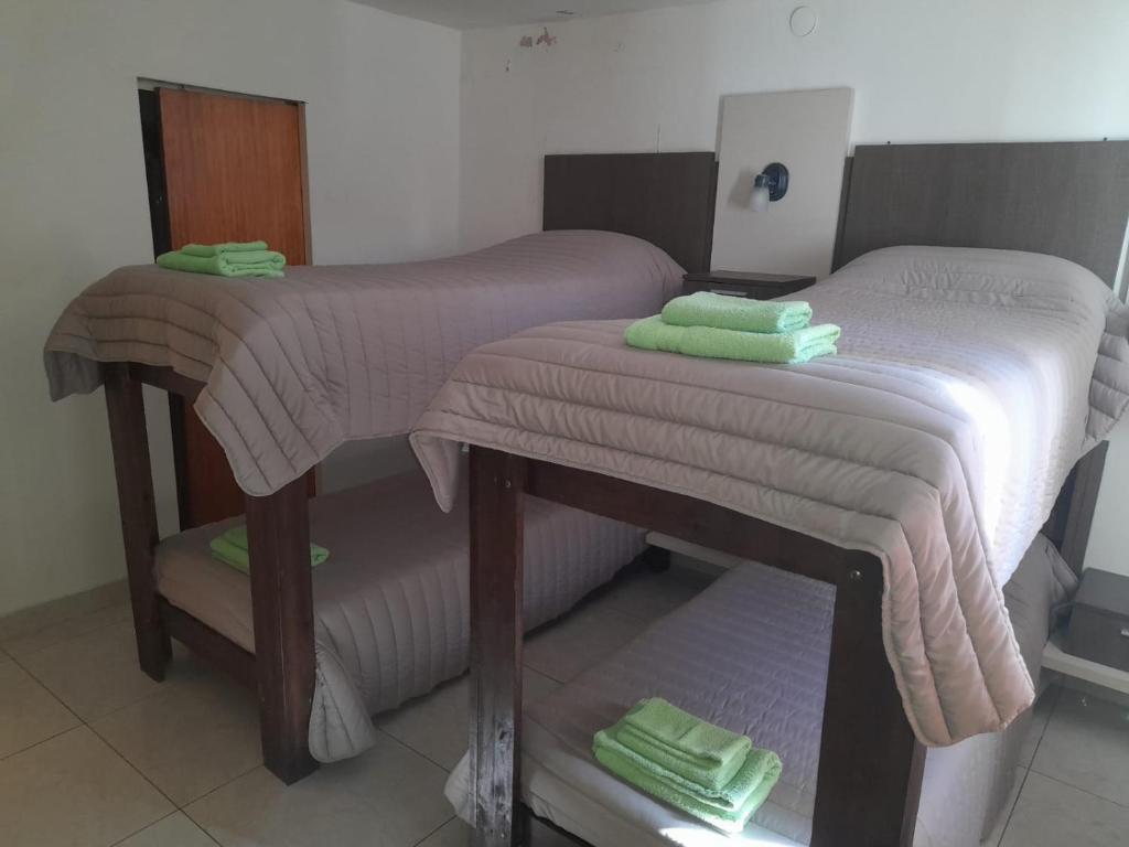 a bedroom with two twin beds with towels on them at Hosteria Catalina in Villa Carlos Paz
