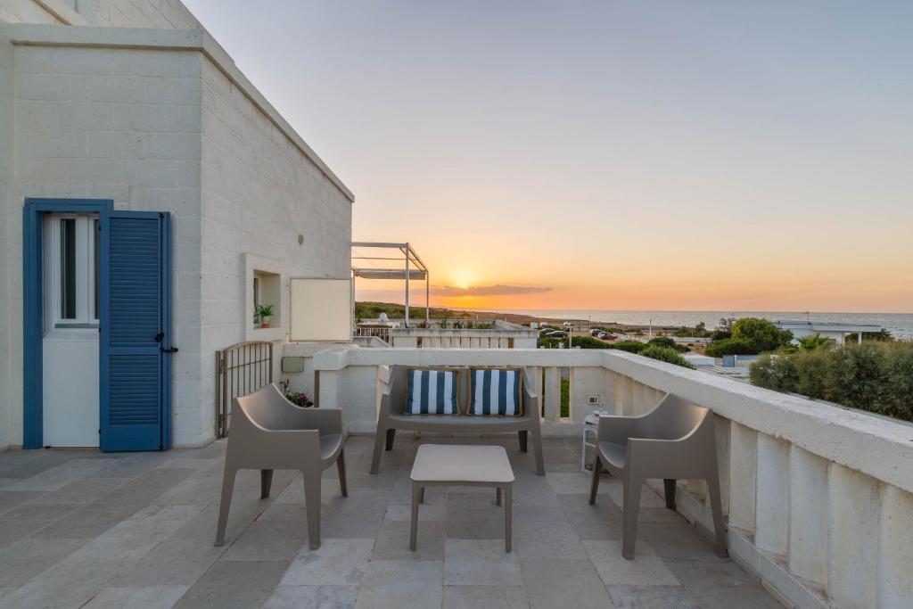 d'un balcon avec des chaises et une table offrant une vue sur l'océan. dans l'établissement Casa D'Amare, à Ostuni Costa Merlata