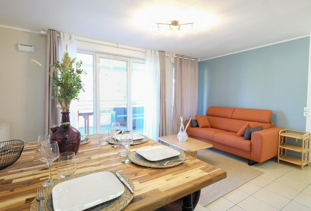 a living room with a table and a couch at Beauregard- Charmant 2 chambres, terrasse & garage in Annecy