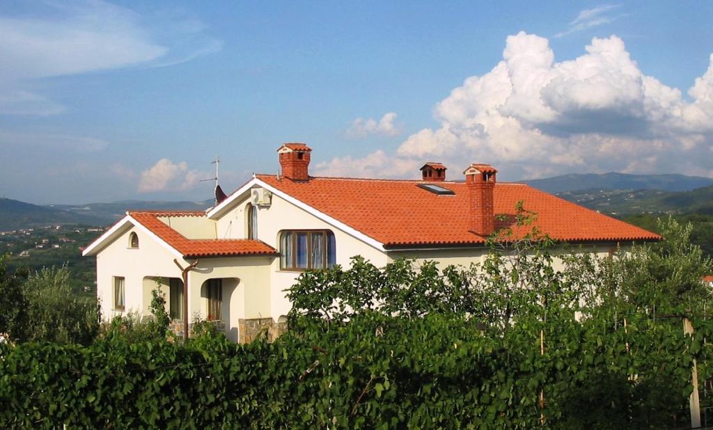 a white house with an orange roof on a hill at Farm stay Domačija Butul in Koper