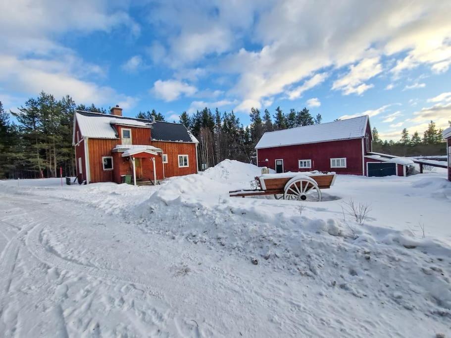 Czerwona stodoła w śniegu obok drogi w obiekcie Ferienhaus am Waldrand w mieście Lillhärdal