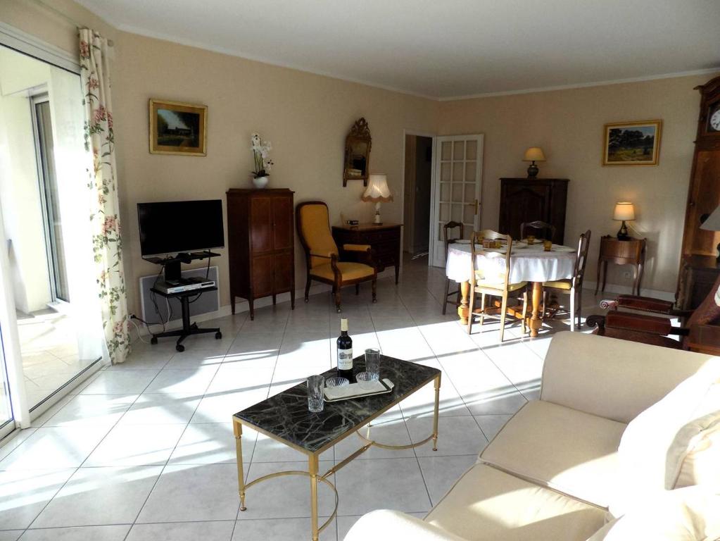 a living room with a couch and a table at Royan - Résidence VILLA BRACELLI - APPARTEMENT SPACIEUX - Centre-ville in Royan
