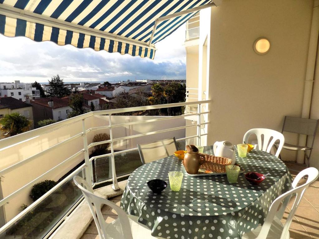 una mesa y sillas en un balcón con vistas en Royan - Résidence VILLA BRACELLI - APPARTEMENT SPACIEUX - Centre-ville, en Royan