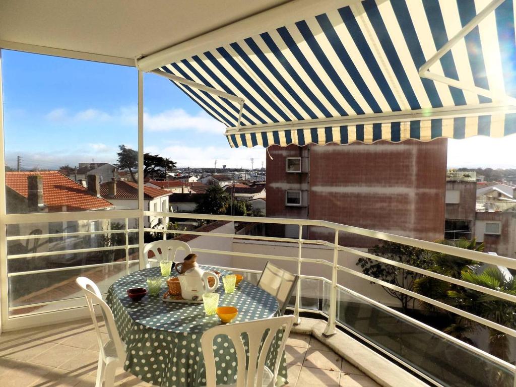 a table and chairs on a balcony with a view at Royan - Résidence VILLA BRACELLI - APPARTEMENT SPACIEUX - Centre-ville in Royan