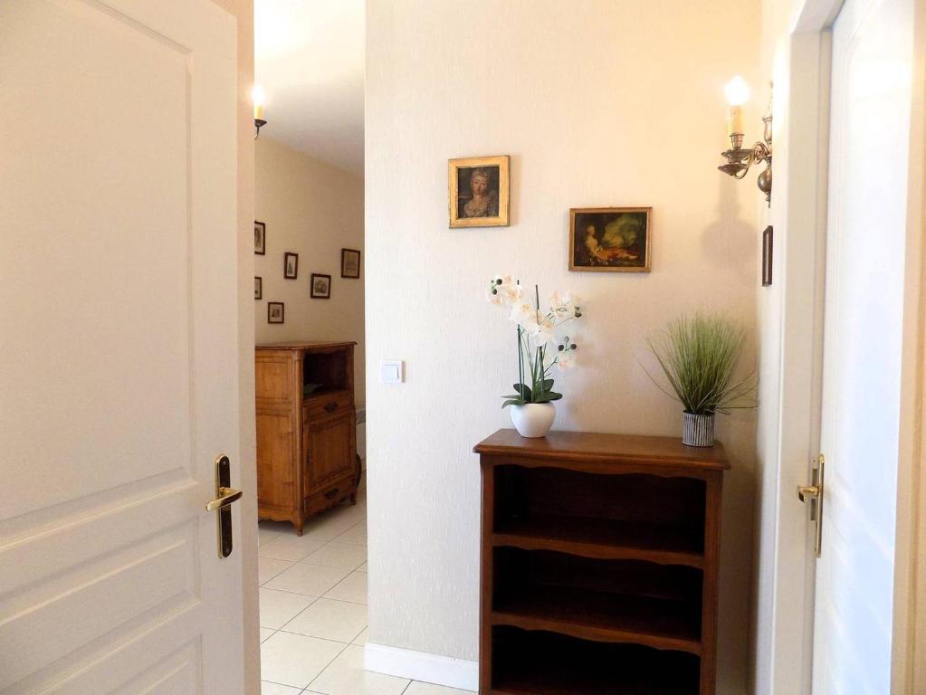 a hallway with a door open to a room with flowers at Royan - Résidence VILLA BRACELLI - APPARTEMENT SPACIEUX - Centre-ville in Royan