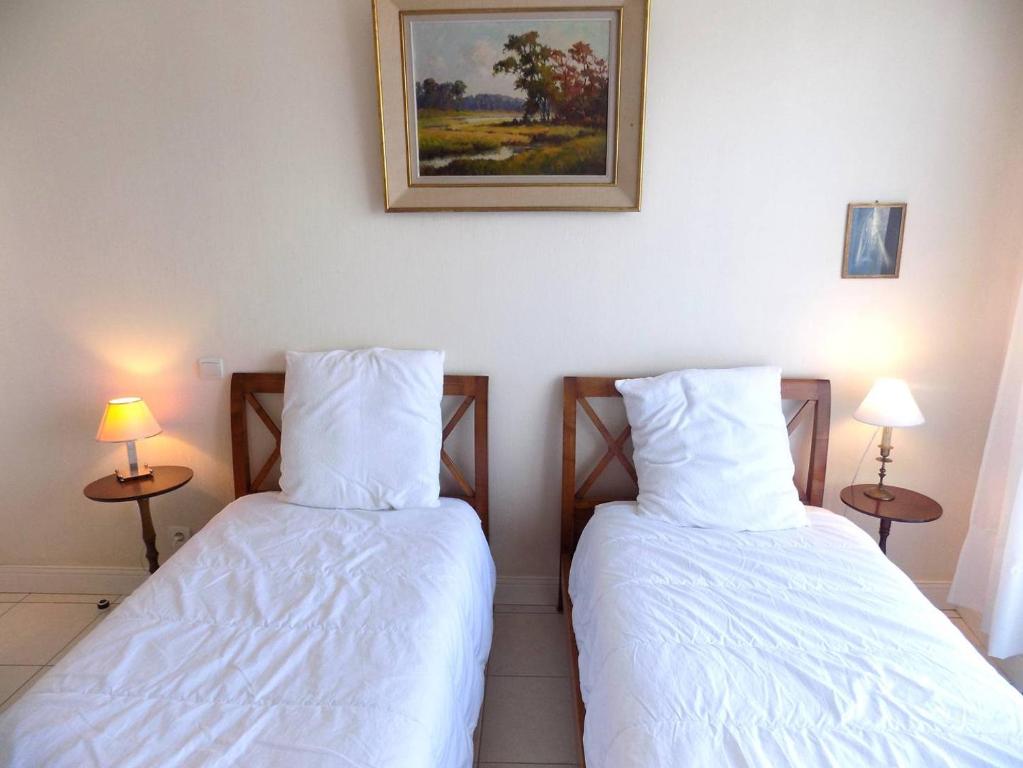 two beds sitting next to each other in a bedroom at Royan - Résidence VILLA BRACELLI - APPARTEMENT SPACIEUX - Centre-ville in Royan