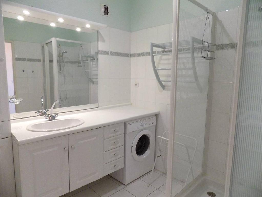 a bathroom with a sink and a washing machine at Royan - Résidence VILLA BRACELLI - APPARTEMENT SPACIEUX - Centre-ville in Royan