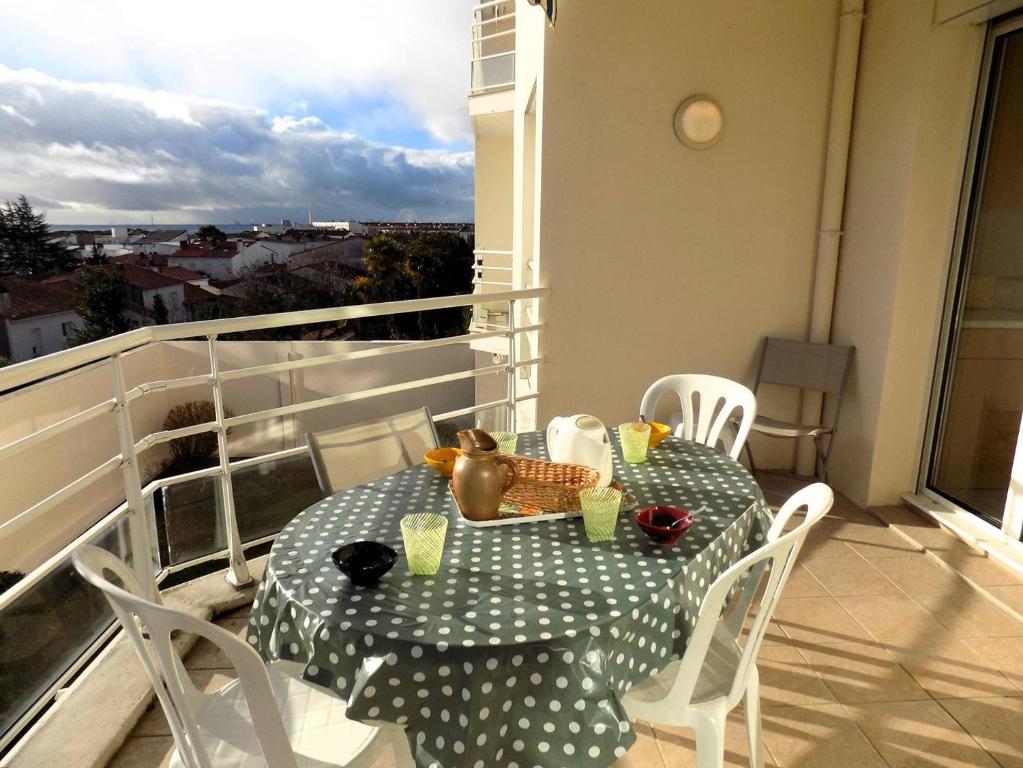a table and chairs on a balcony with a table and a view at Royan - Résidence VILLA BRACELLI - APPARTEMENT SPACIEUX - Centre-ville in Royan