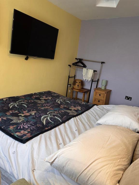 a bedroom with a bed and a flat screen tv at Hidden Gem in Great Parndon