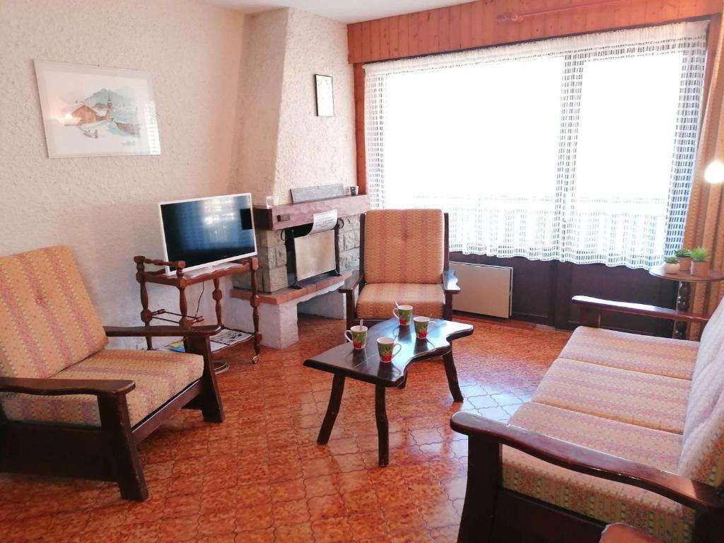 a living room with a couch and a tv at Appartement Le Grand-Bornand, 1 pièce, 5 personnes - FR-1-241-202 in Le Grand-Bornand