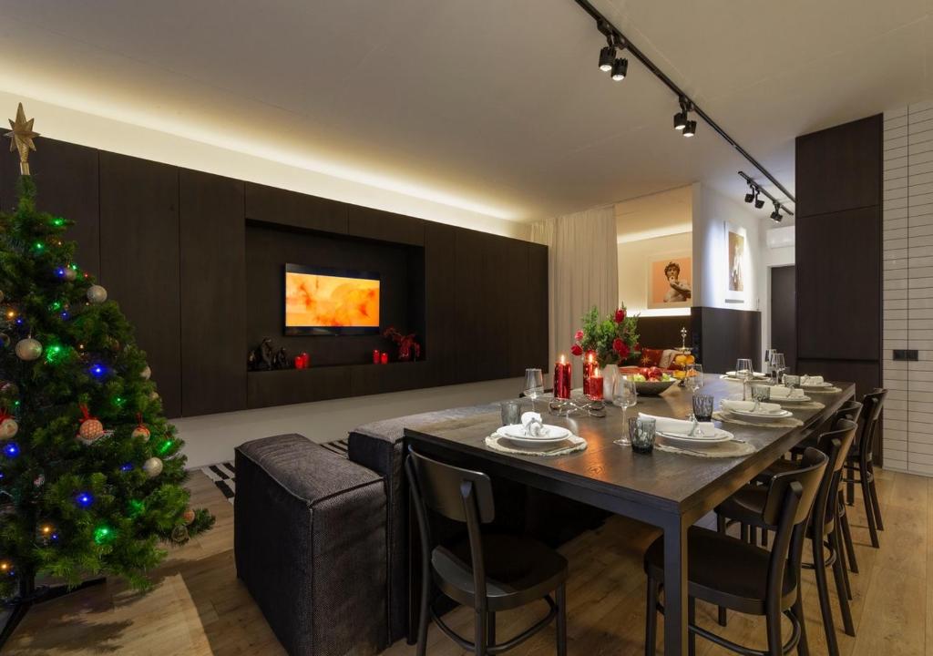 a dining room with a table and a christmas tree at Stylish 1 bedroom studio near Most City in Dnipro