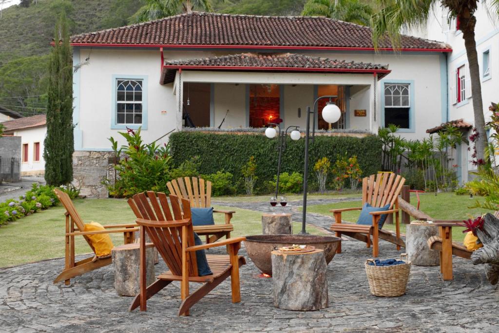 un grupo de sillas y una mesa frente a una casa en Hotel Girassol da Serra, en Santa Maria Madalena