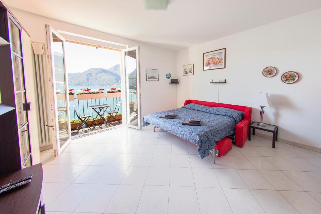 een slaapkamer met een bed en een balkon bij Deluxe finestra sul lago in Bellano