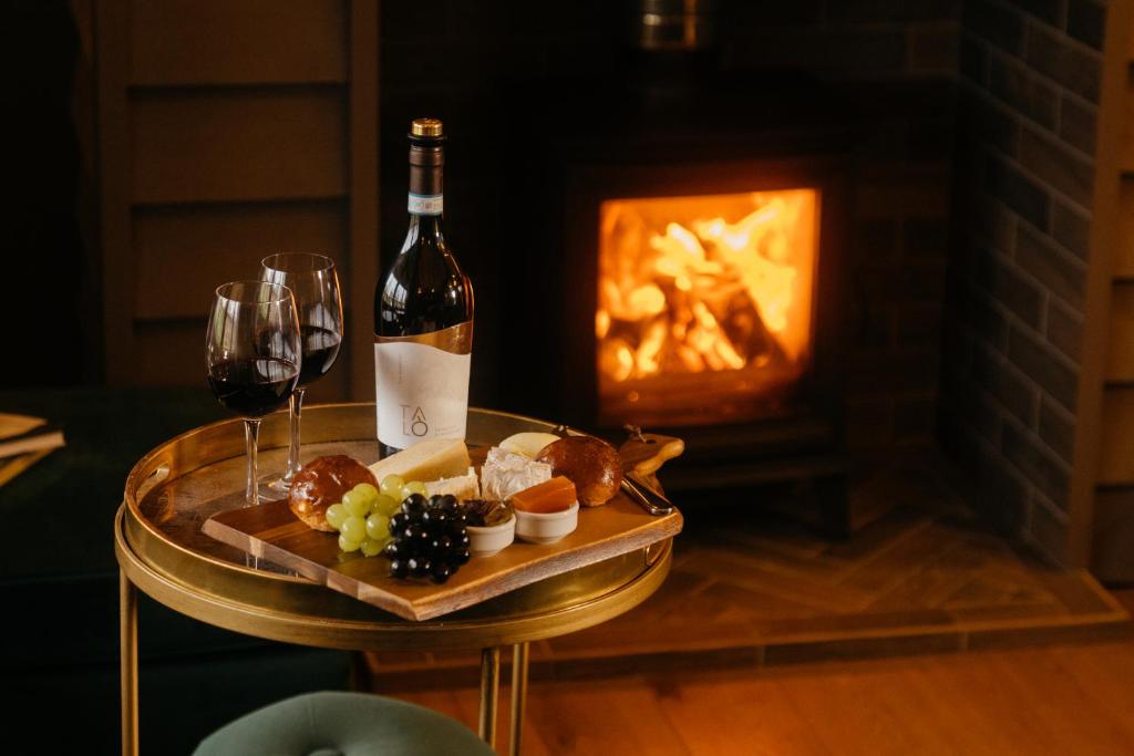 eine Flasche Wein und ein Tablett mit Speisen und Weingläsern in der Unterkunft Retreat East in Ipswich