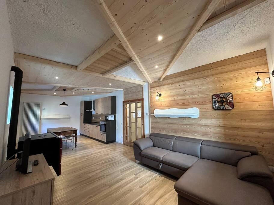 ein Wohnzimmer mit einem Sofa und einem Tisch in der Unterkunft Appartamento Chalet Bernardi in Caderzone