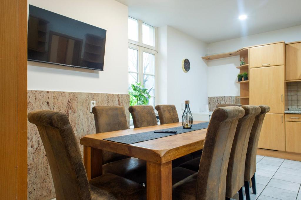 comedor con mesa de madera y sillas en Work & Stay Apartment Bedburg Hau en Hau
