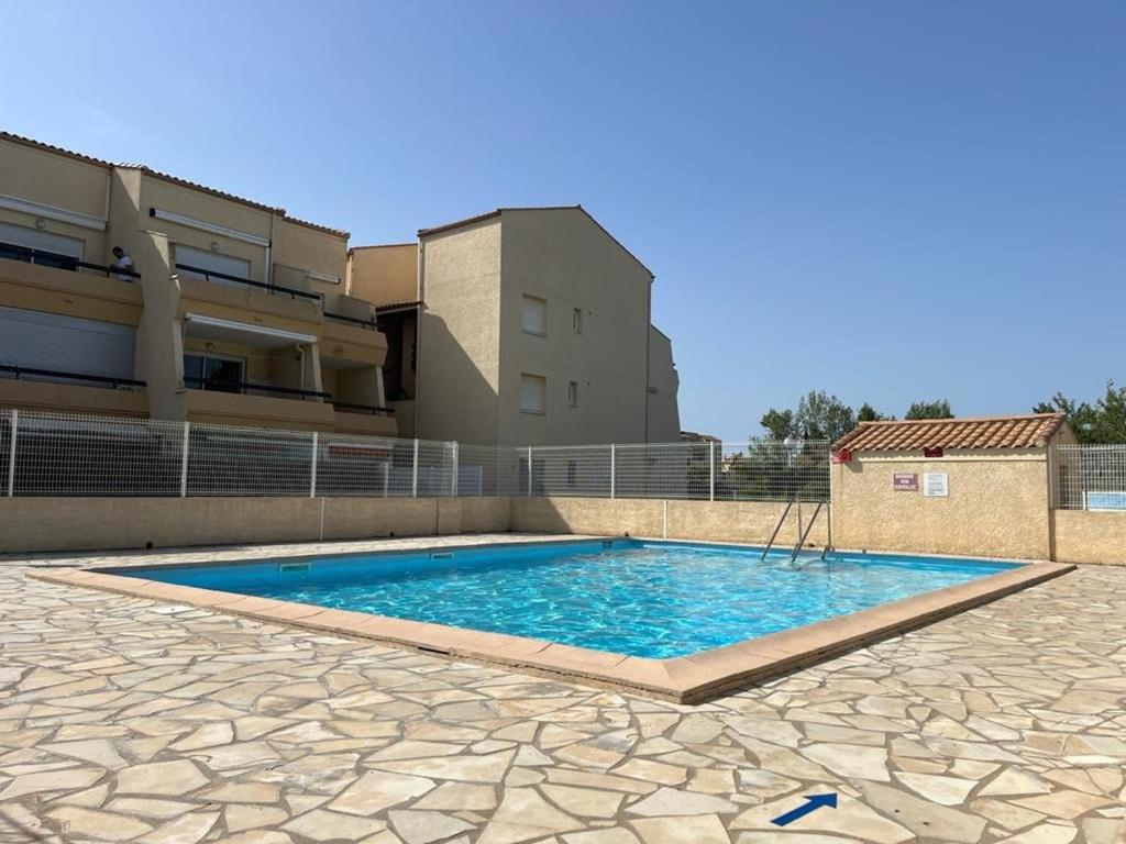 une piscine devant un immeuble dans l'établissement Studio Cabine Climatisé avec Piscine, Terrasse et Parking Privé – Proche Commodités - FR-1-387-137, à Marseillan