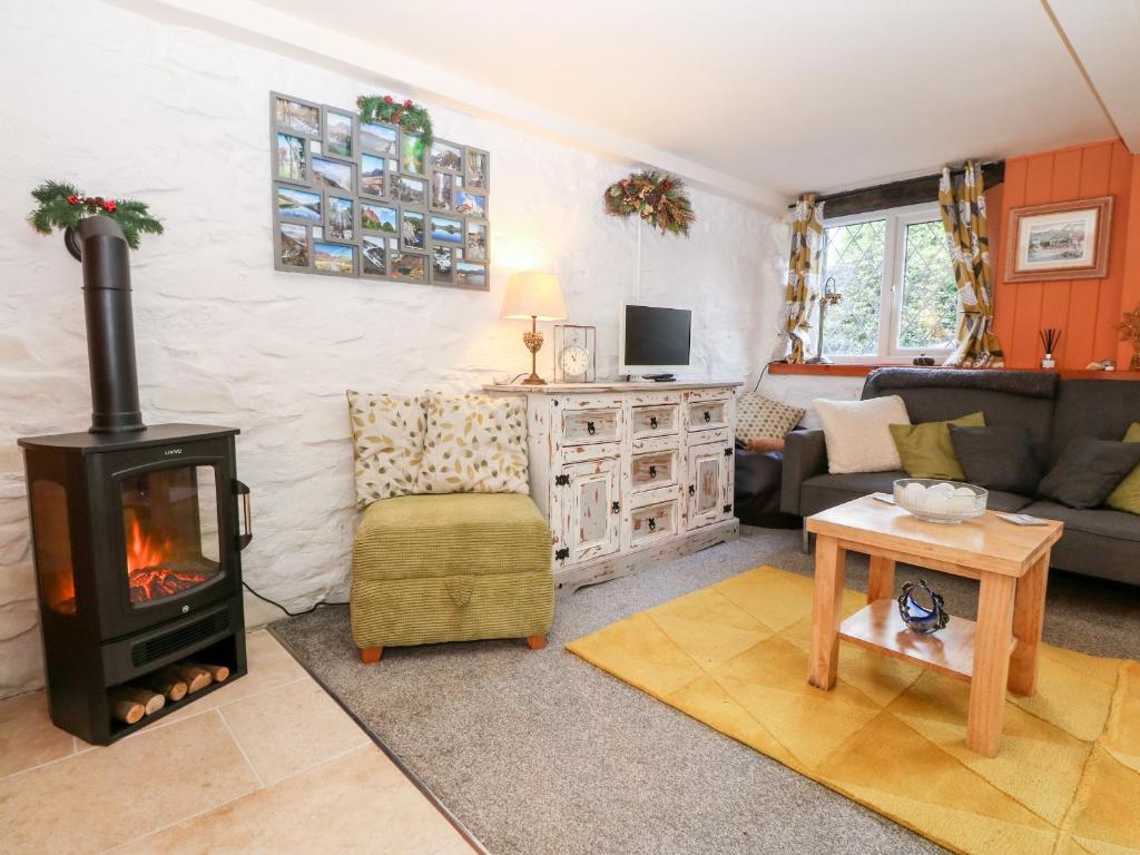 a living room with a fireplace and a couch at Yr Hen Efail in Welshpool
