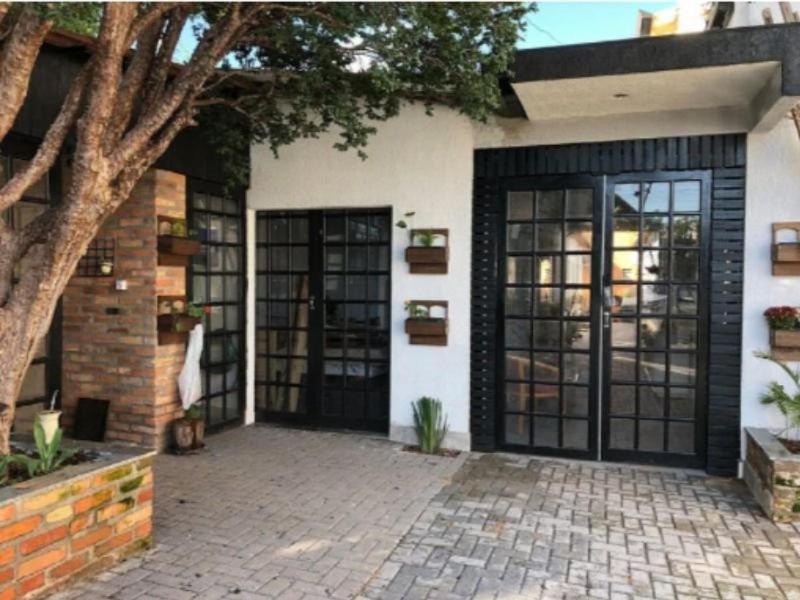 a house with black doors and a brick patio at Studio acolhedor em região central de Foz in Foz do Iguaçu