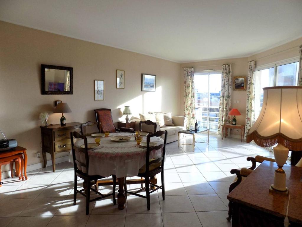 a living room with a table and chairs and a couch at Royan - Résidence VILLA BRACELLI - APPARTEMENT SPACIEUX - Centre-ville in Royan