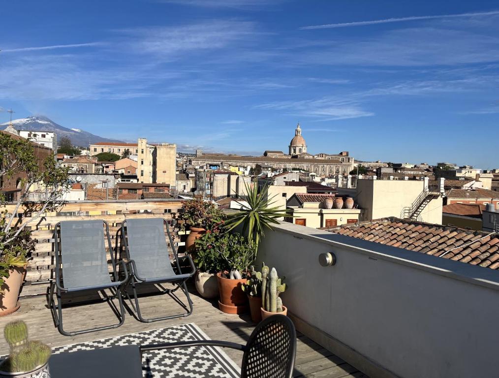 a balcony with two chairs and a view of a city at Trìcora Sicilian B&B in Catania