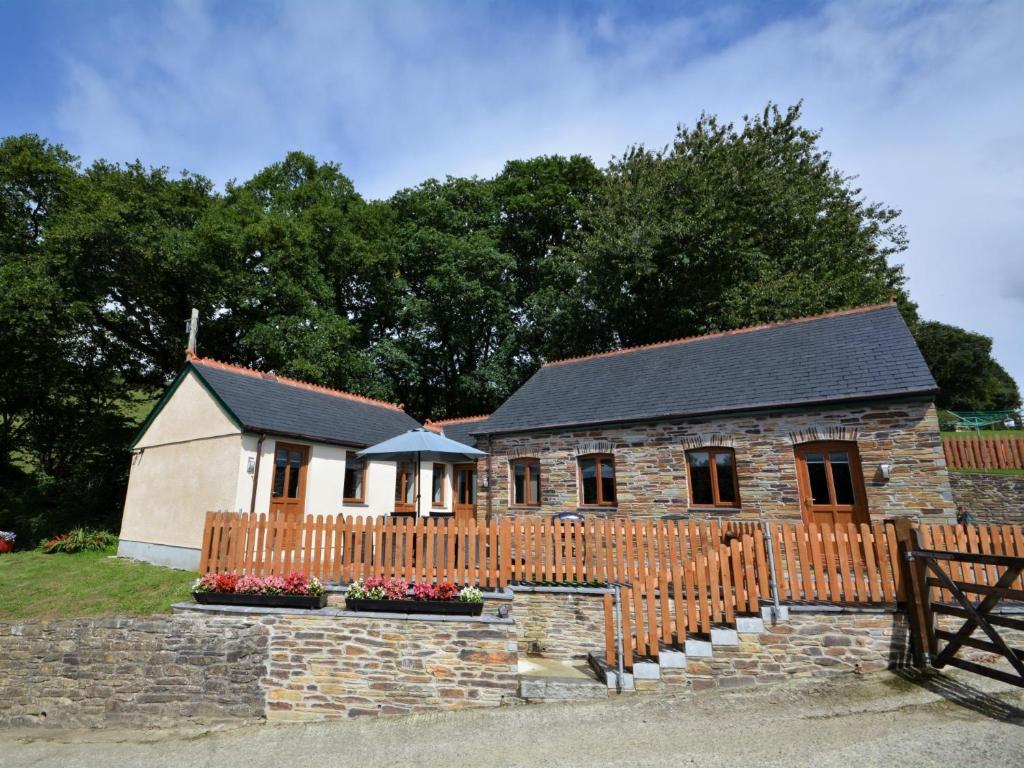 a small church with a wooden fence and a building at 3 bed in Fowey 53664 in Warleggan