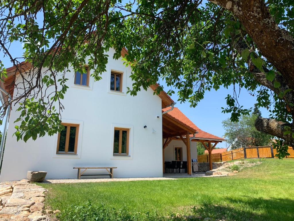 Podhradí Landštejn في سلافونيتسا: أمامه بيت أبيض ومقاعد للتنزه