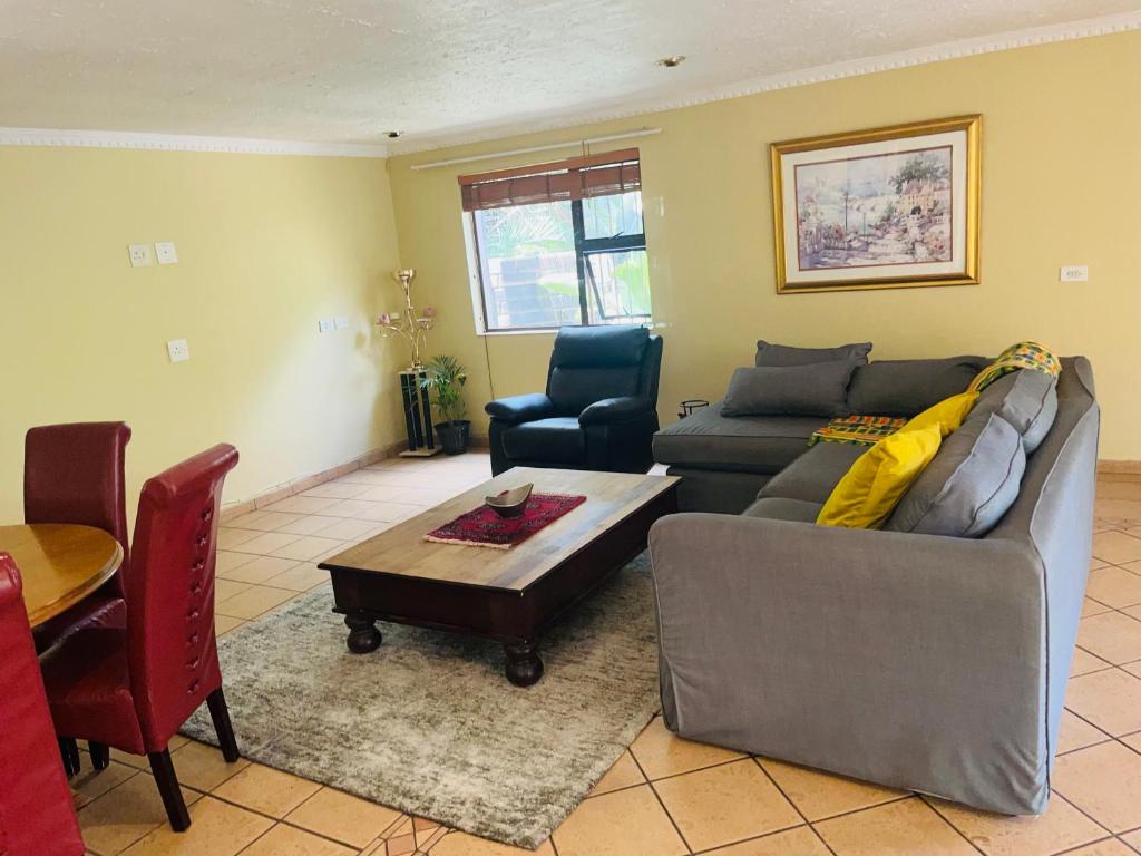 a living room with a couch and a table at Spacious peaceful 5 bedroom house in Pretoria