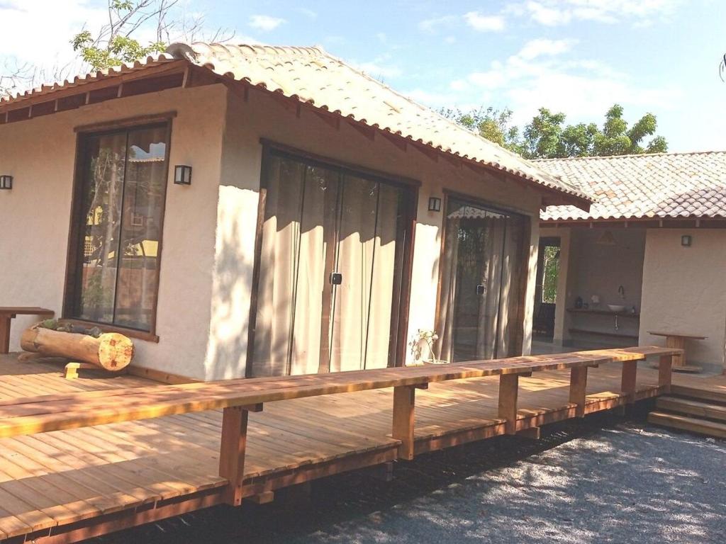 Chalé Buriti في بونيتو: منزل صغير مع شرفة خشبية كبيرة