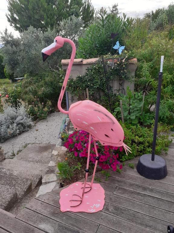 a pink flamingo statue in a garden with flowers at Petit Paradis chez Pascale et Bernard in Cazouls-lès-Béziers