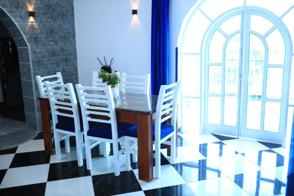 a dining room with a table and chairs and a window at Villa Kaslan Apartments in Luxor