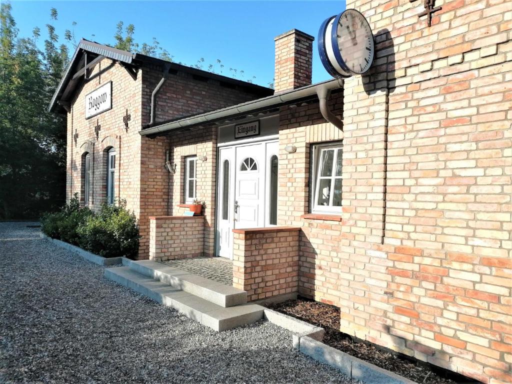 a brick building with a clock on the side of it at Ferienwohnung mit Meerblick, Balkon und Kamin OFC 06 in Roggow