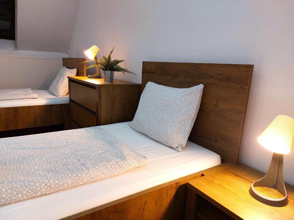 a room with two beds with a lamp and a pillow at Black Sheep Budapest Smart Rooms in Budapest