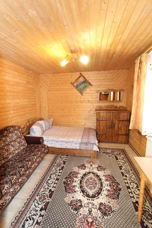 a room with a bed and a couch in a room at Садиба "Svitlana" in Yablunytsya