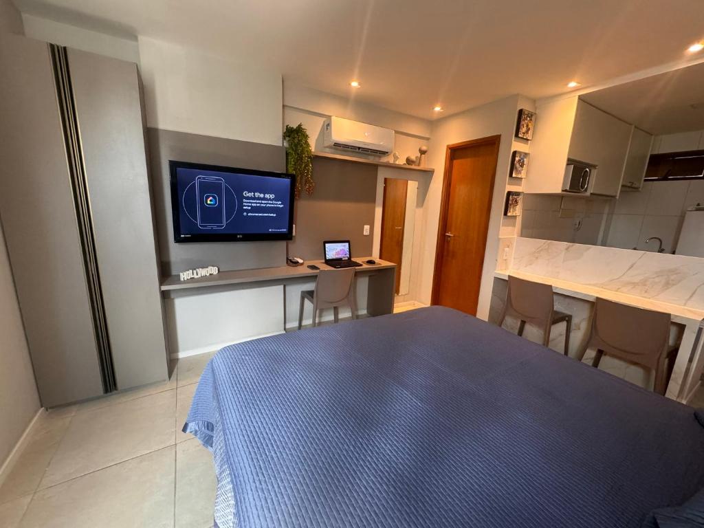 a room with a bed and a kitchen with a television at Flat localizado a 200m Shopping Recife, bem Perto da Praia de Boa Viagem e com Wi-Fi 400Mbps in Recife