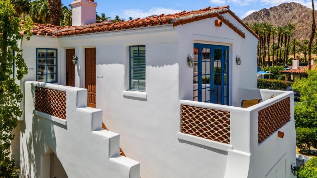 a white house with blue doors and stairs at SV113 Airy Spa Villa 1 Bedroom in Prime Location in La Quinta