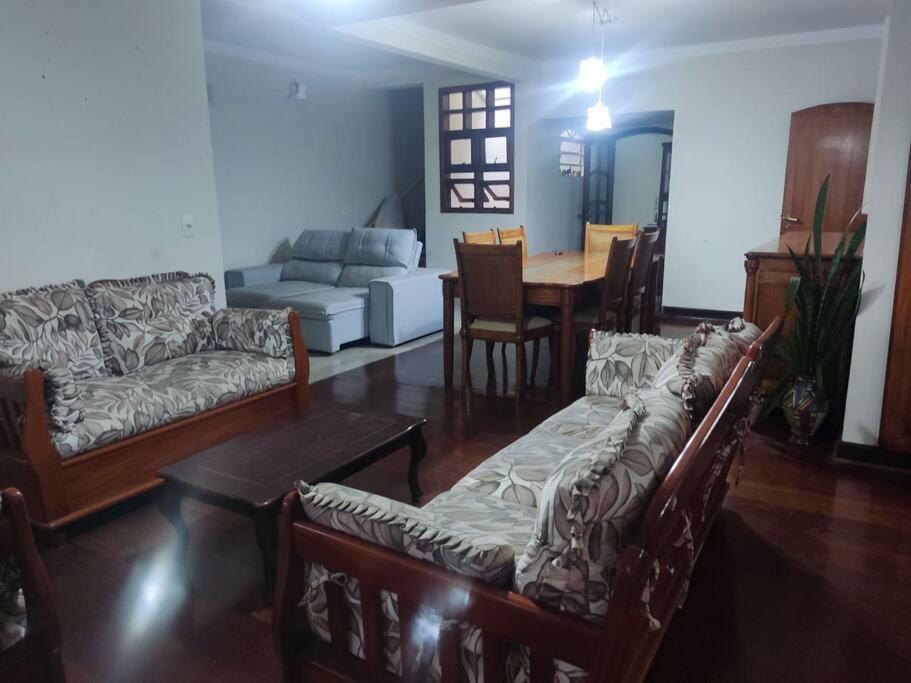 a living room with couches and a dining room at Casa rústica Jardim Abaete in Piracicaba