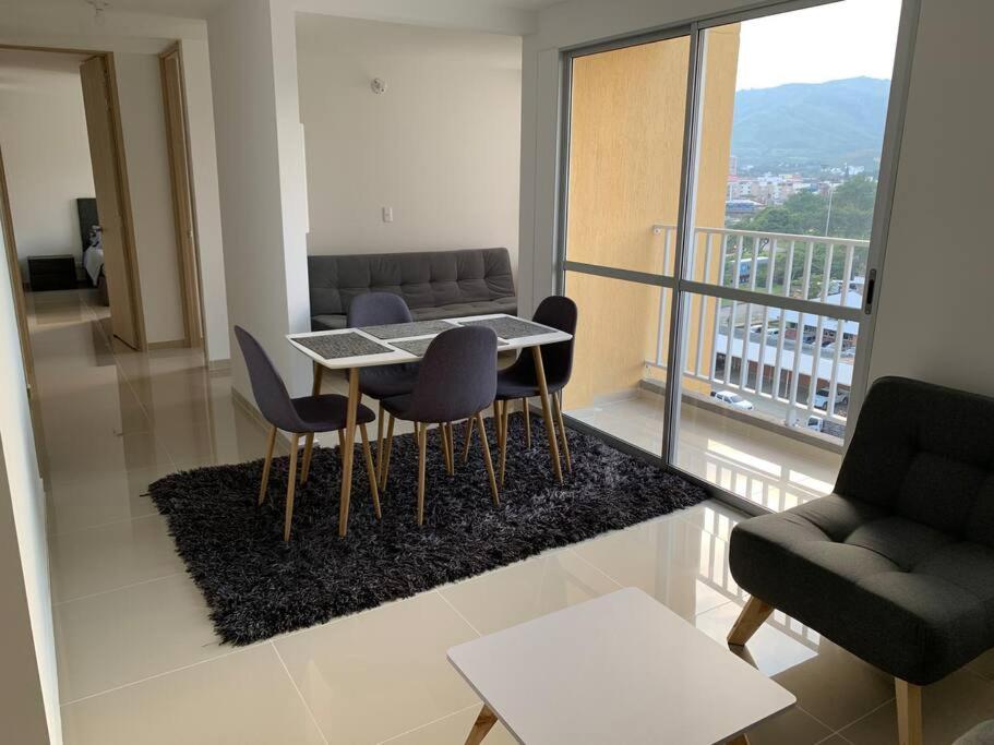 een woonkamer met een tafel en stoelen en een balkon bij Apartamento nuevo norte Cali in Cali