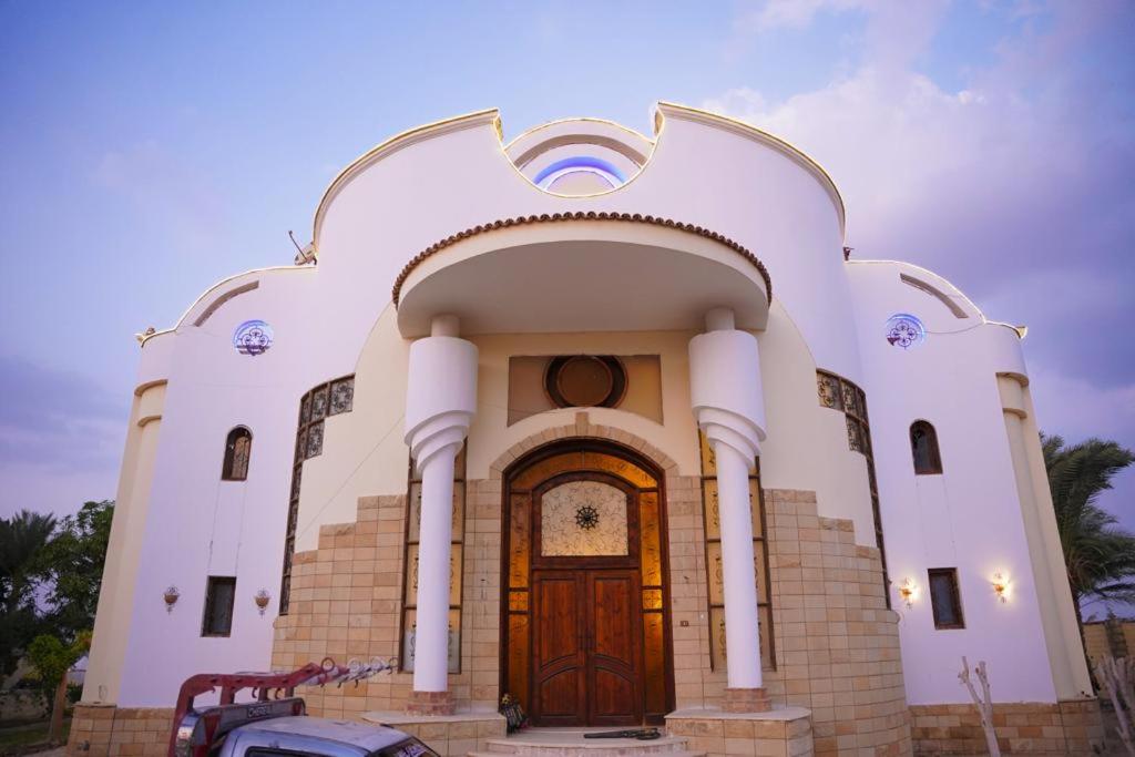 a large white church with a wooden door at Tunis Beach Families Only in Fayoum Center