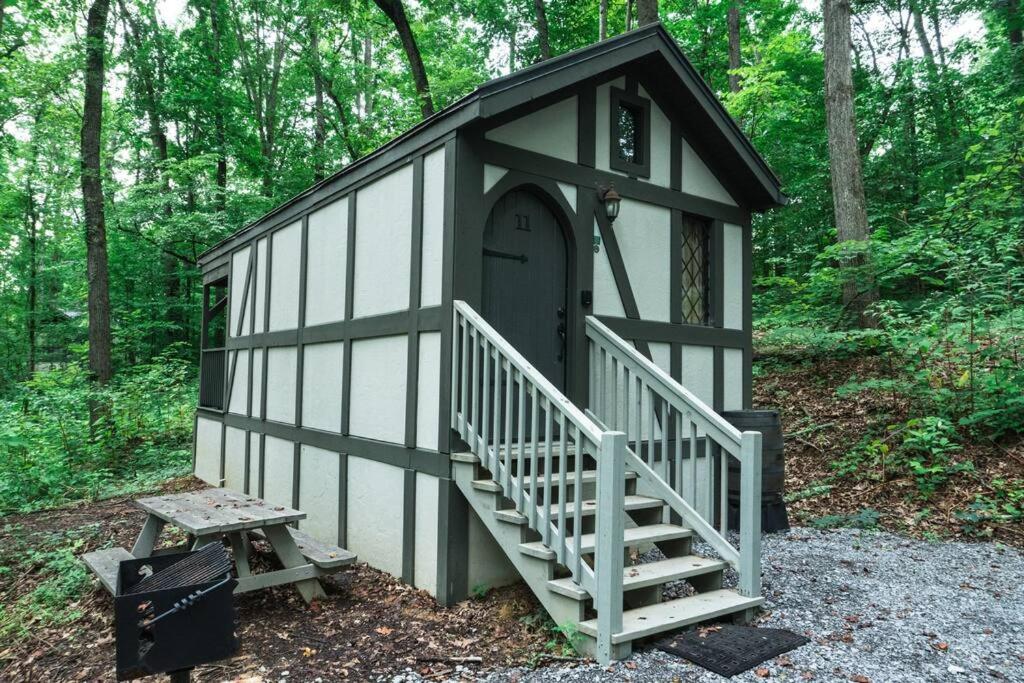a small building with a staircase in the woods at Tiny Home Cottage Near the Smokies #11 Mina in Sevierville