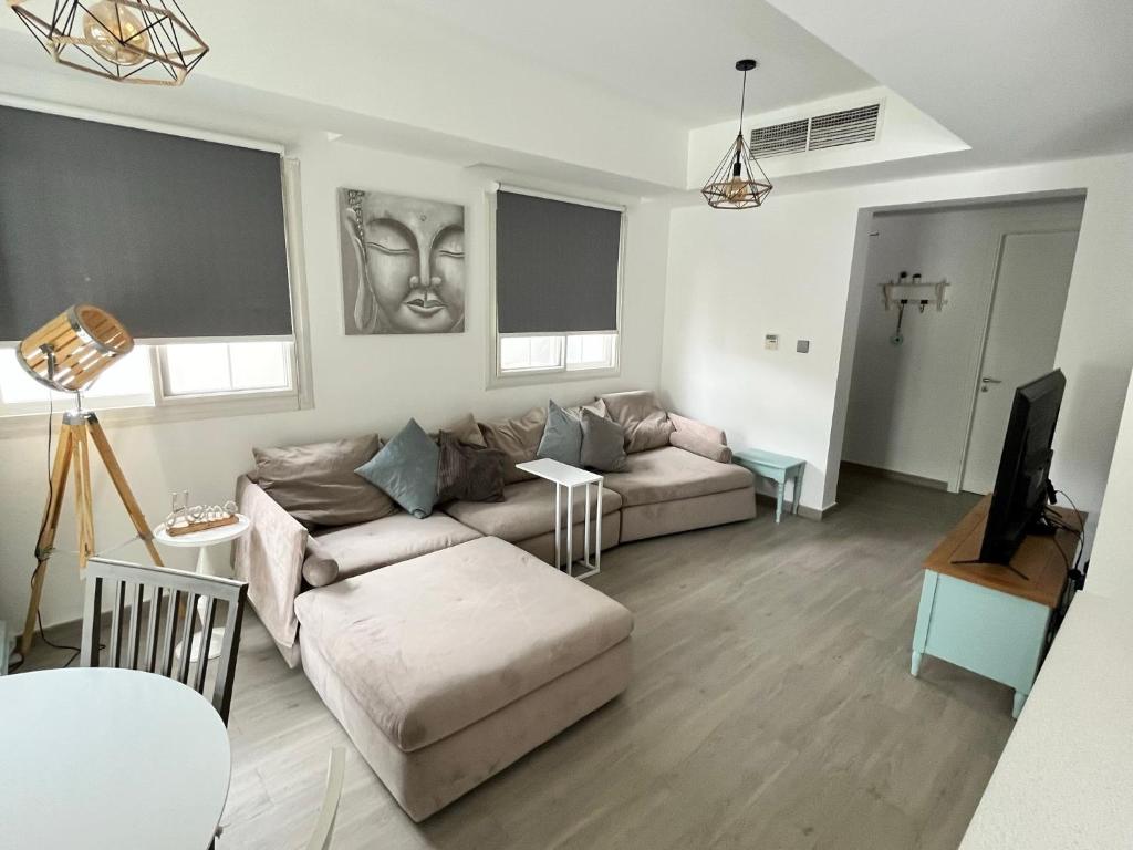 sala de estar con 2 sofás y TV en Charming villa w/ private garden en Dubái
