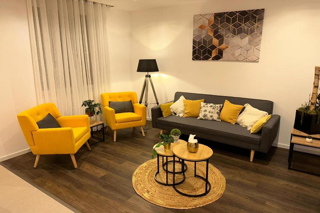 a living room with yellow chairs and a couch at Le Parilly charmant deux chambres République in Villeurbanne