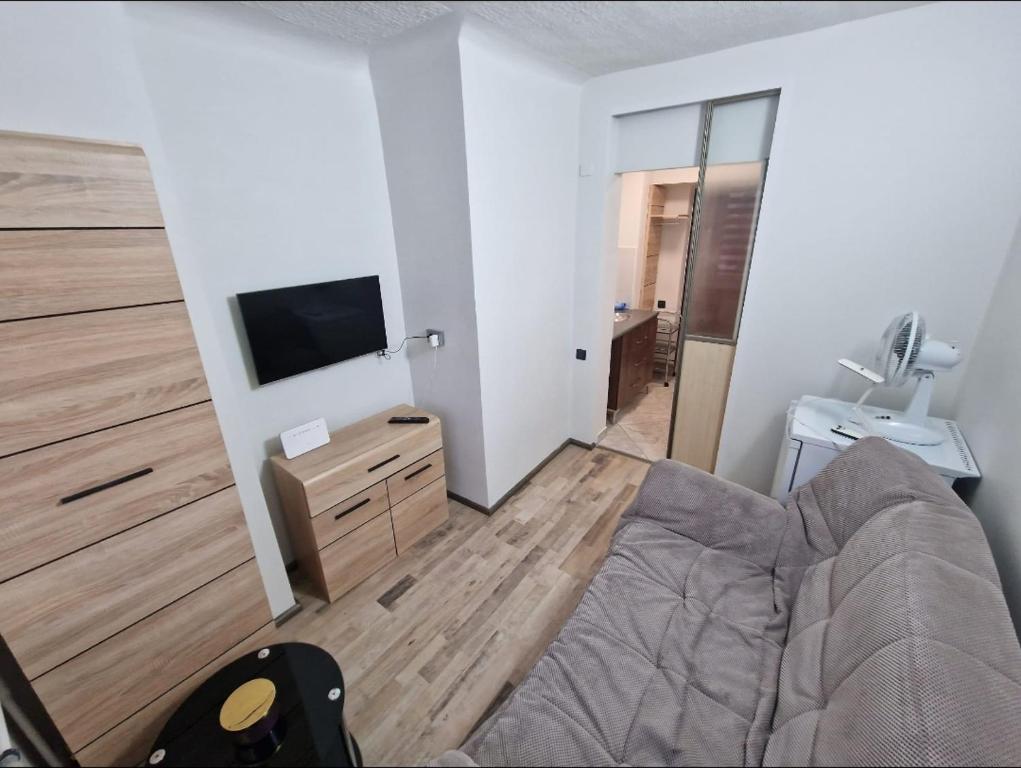 a bedroom with a bed and a flat screen tv at Cozy apartments in the center of Liepaja in Liepāja