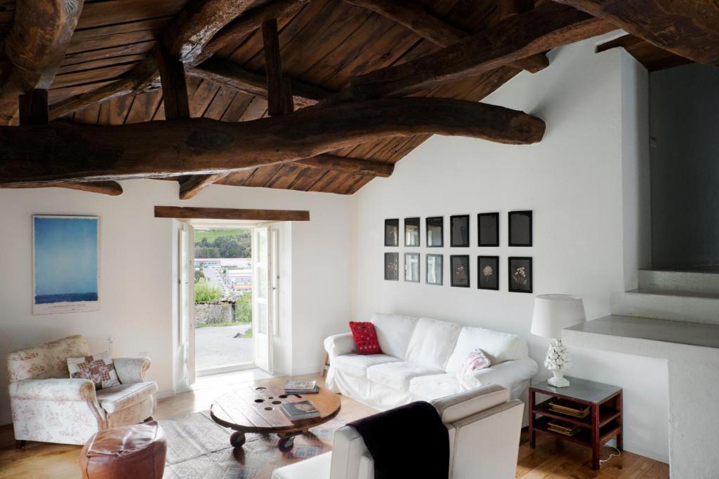 een woonkamer met een witte bank en een tafel bij Casa de las Flores / Casa de campo LUGO in A Pontenova